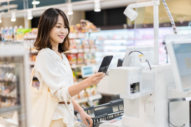 セルフレジで買い物をする女性