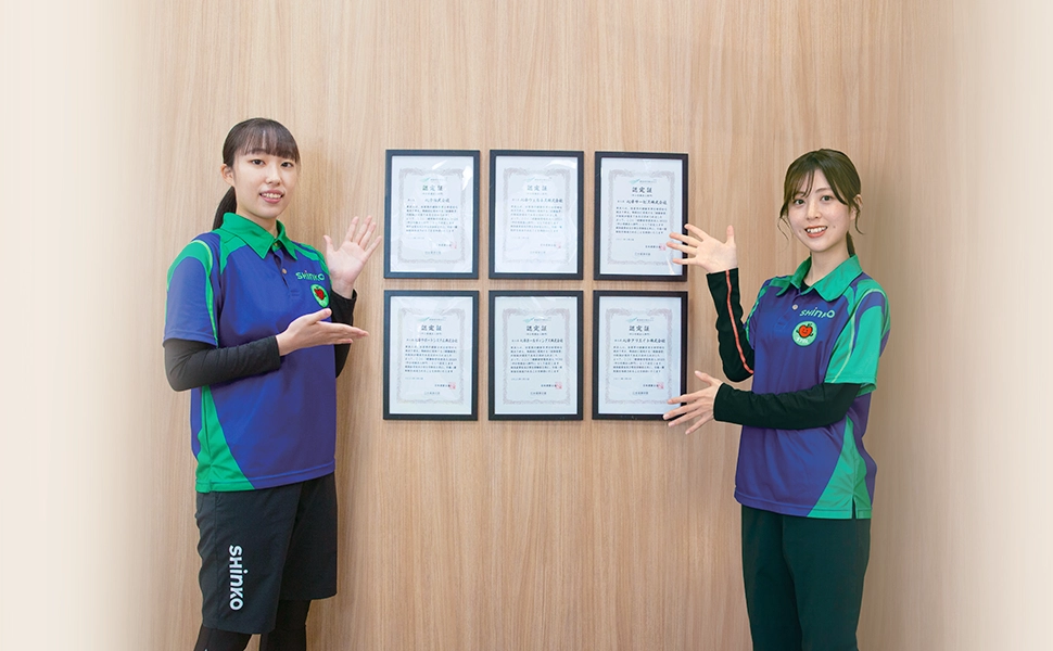 健康経営優良法人認定証を前に笑顔のオフけんスタッフ