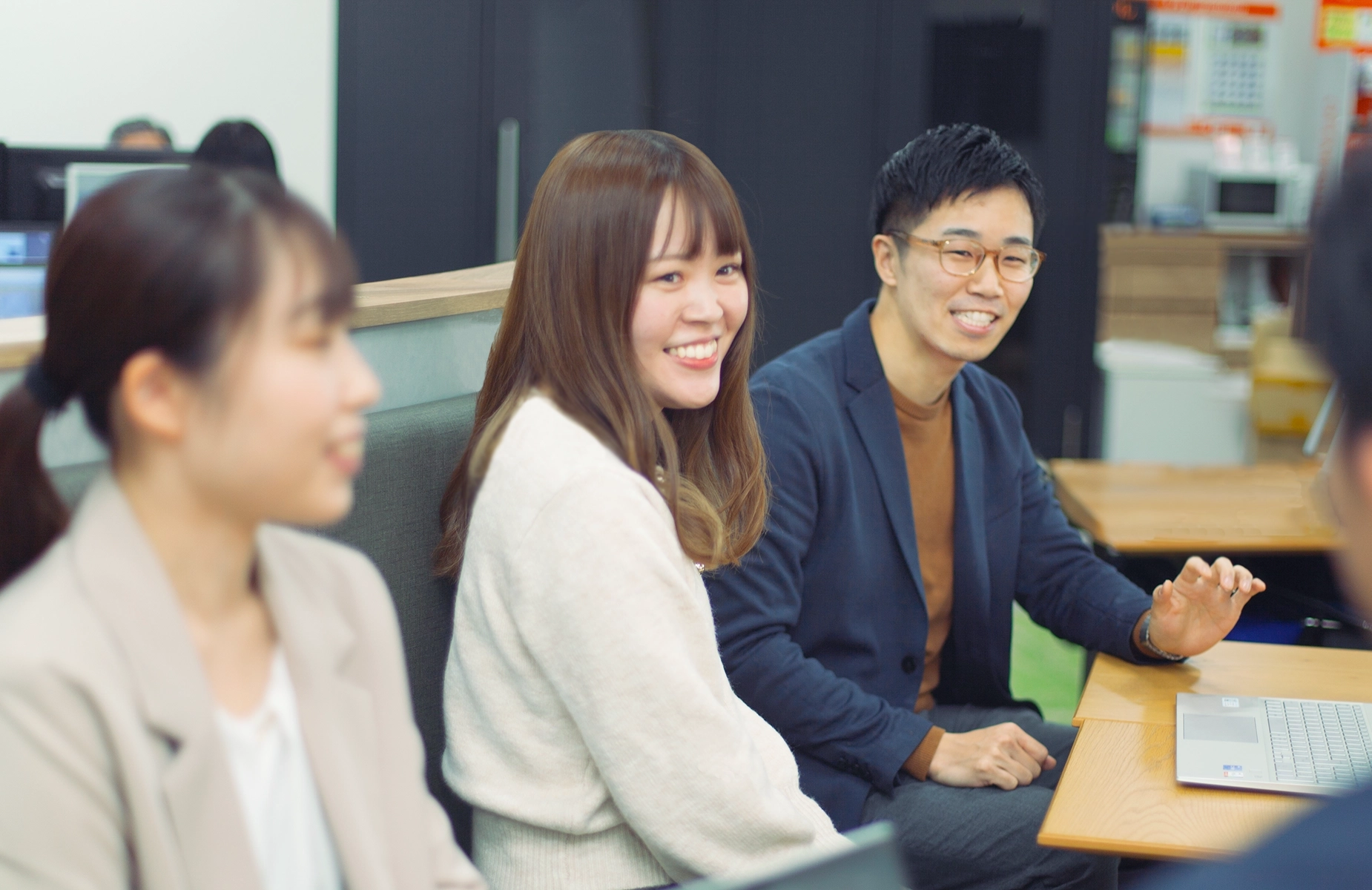 オフィスで元気よく意見交換しながら働く心幸グループの社員たち