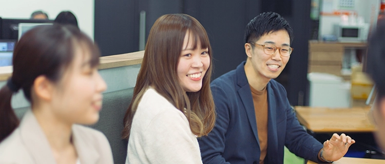 オフィスで元気よく意見交換しながら働く心幸グループの社員たち